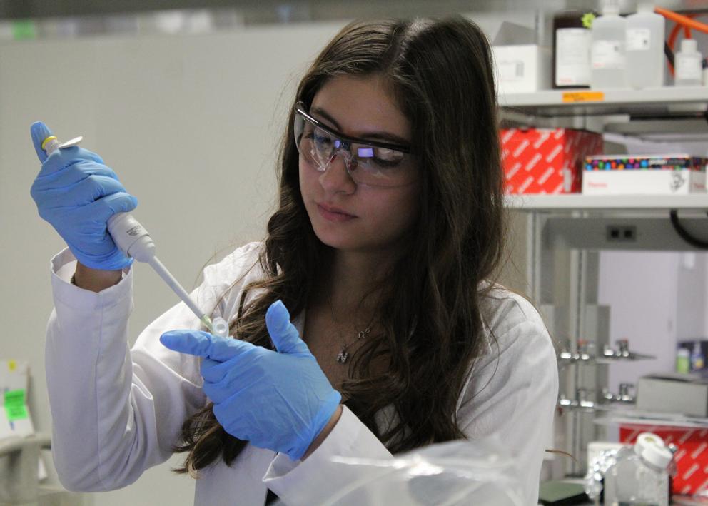 Graduate student Nicole Montoya in the Shiflett lab holding a pipette and tube wearing lab PPE
