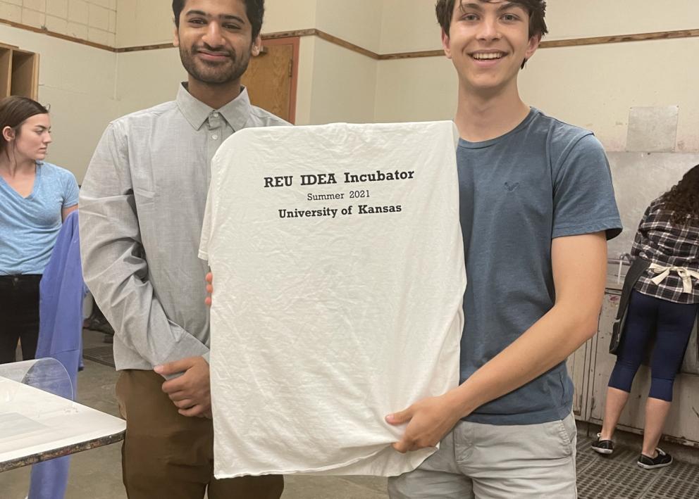 Abdul and Eli showing their REU IDEA Incubator t-shirt they screen printed