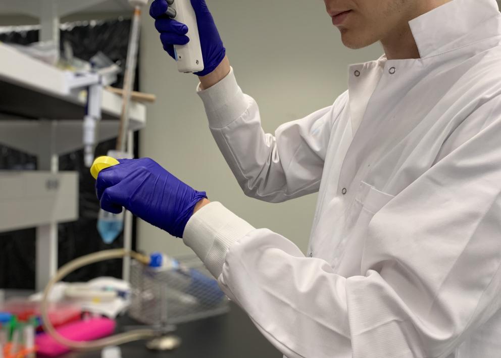 REU student Eli pipetting in the lab