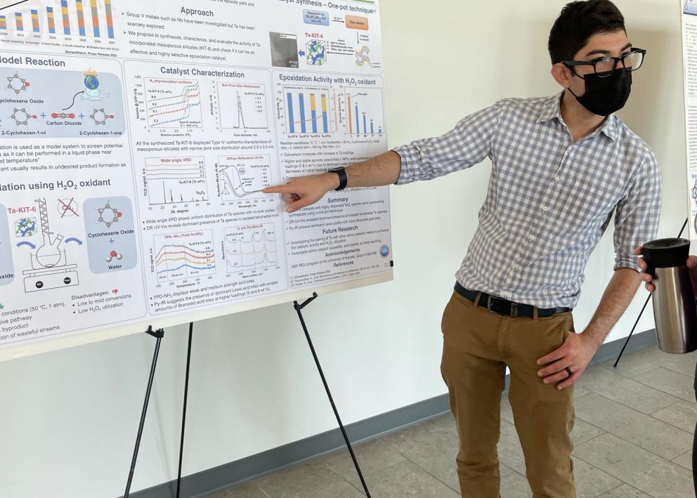 Gustavo explaining graph on his poster at the REU poster session
