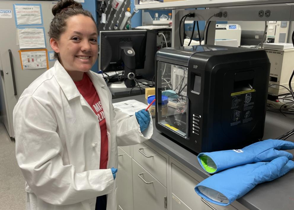Student in lab transferring a sample into a characterization device