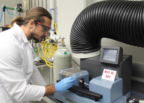 Graduate student Nicolas Reding working on TGADSC equipment in the Shiflett lab wearing PPE