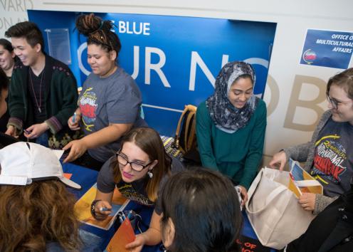 Students crowding around a booth during an event
