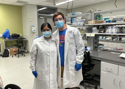 REU students Anika and Gabe posing for a picture in the lab with full safety gear