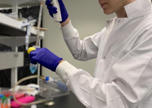 REU student Eli pipetting in the lab