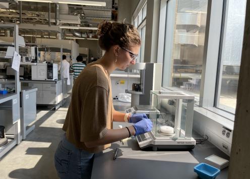 Student weighing out a sample on scale in the laboratory