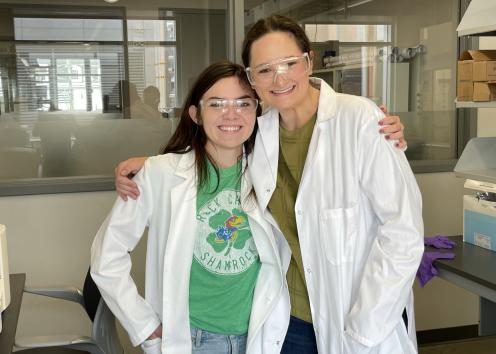 Two students posing and smiling for picture in lab