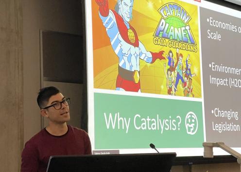 Student giving presentation with slide "Why catalysis" in background