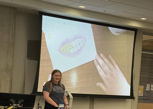 Student explaining their drawing of teeth to represent scale