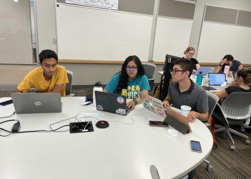 Saurav, Anika, and Gustavo working on laptops at a table in LEEP2