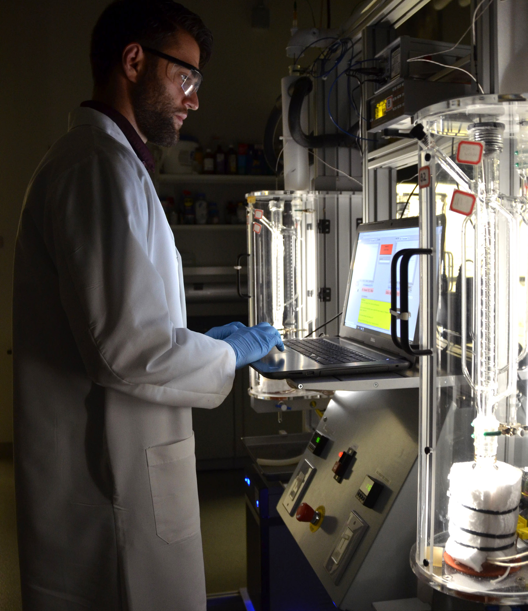 A person in a lab coat at a computer