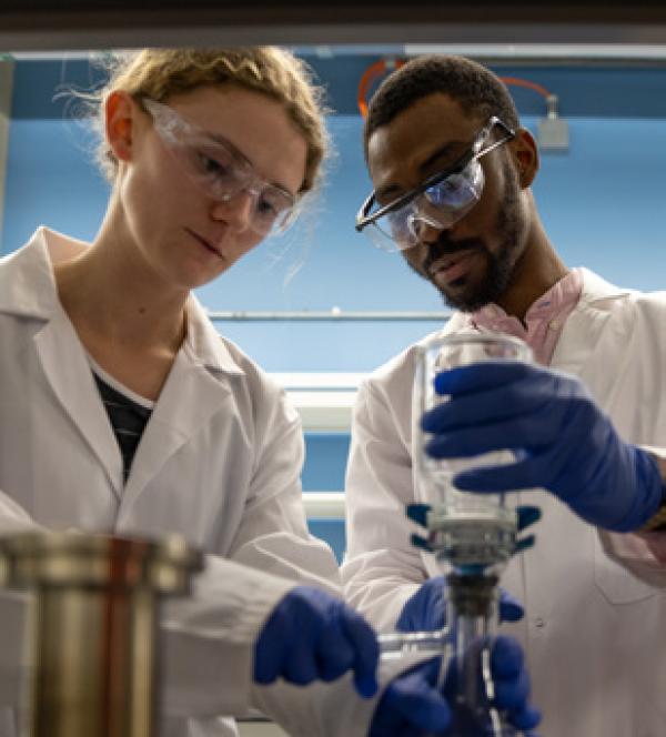 two people work with beakers and pipettes