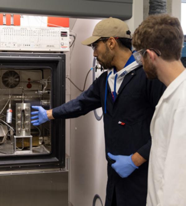 One person showing a piece of equipment to another