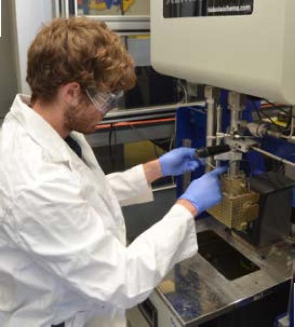 a student adjusts a piece of lab equipment